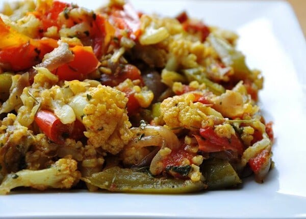 A plate of colorful mixed vegetables including cauliflower, bell peppers, and onions, seasoned and cooked.