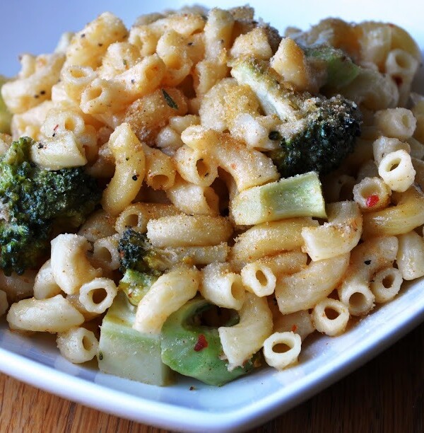 A bowl of pasta with broccoli, seasoned with cheese and pepper, served in a white dish.