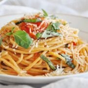 A plate of easy Spaghetti al Pomodoro with fresh tomatoes, topped with basil and grated cheese.