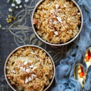Two bowls of cooked bulgur topped with chopped almonds, placed on a decorative fabric surface.