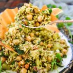 Bhel Puri featured image with a large spoonful of bhel including murmura, chickpeas, and papad.