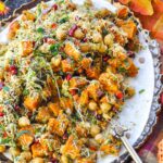 Sweet potato chaat platter with a large spoon filled with sweet potatoes.