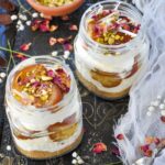 Gulab Jamun Cheese Mason Jars layered with cheesecake and gulab jamun, then garnished with rose petals.