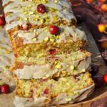 Cranberry Pistachio Bread with Orange Glaze sliced with a few cranberries and chopped pistachios on top.
