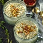 Pistachio Overnight Oats in a fancy glass mug topped with chopped pistachios and a few saffron threads.