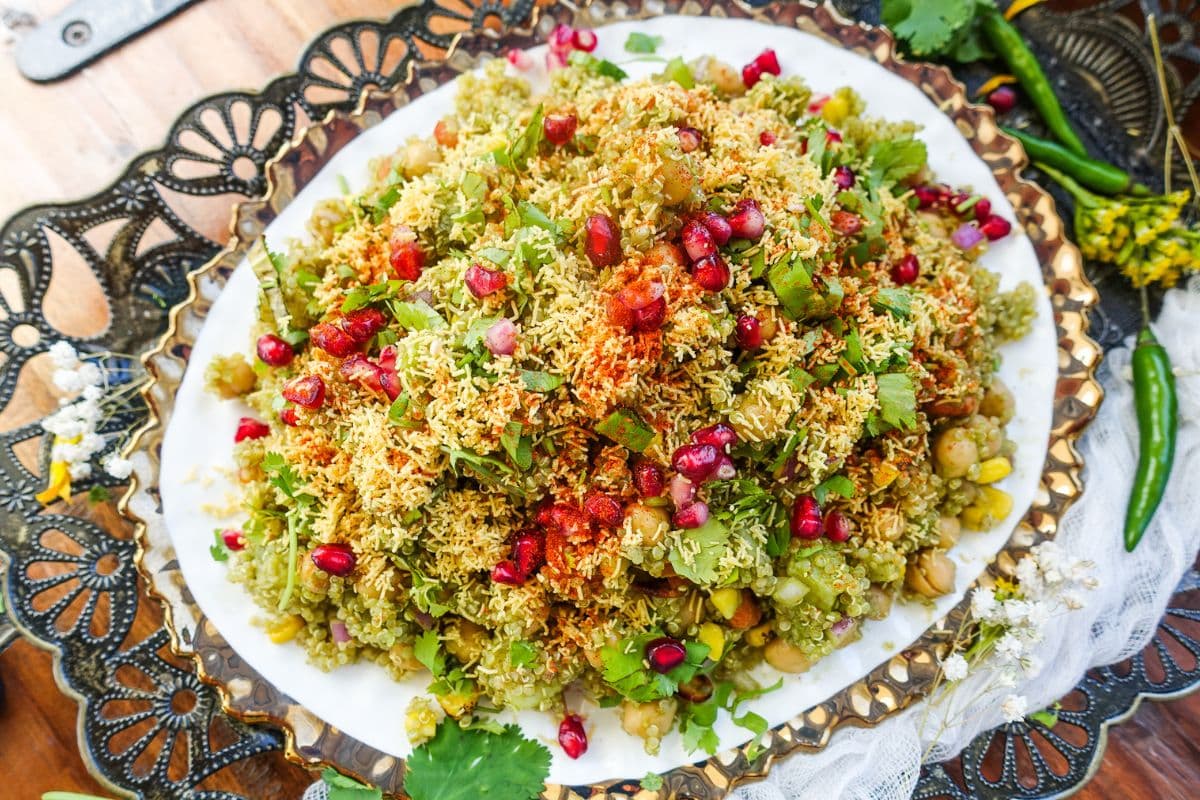 Quinoa Bhel Salad garnished with fine sev, pomegranate, and red chili powder.