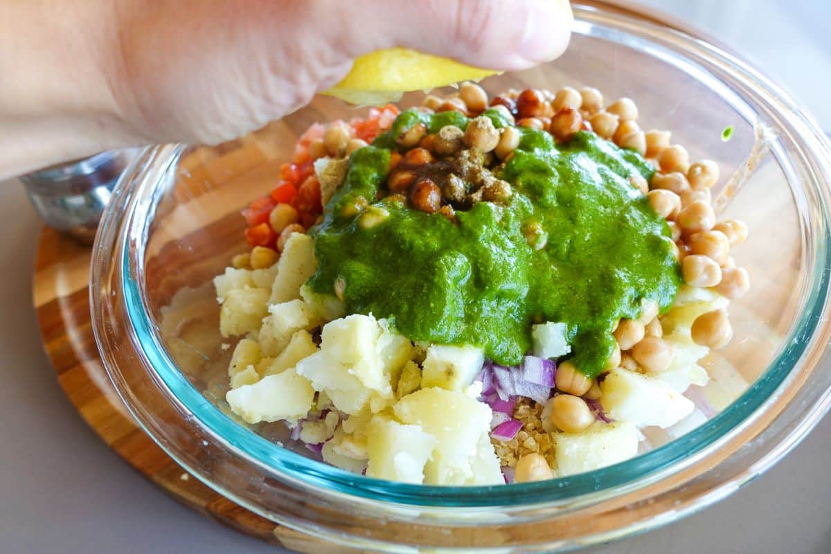 A clear bowl with a squeeze of lemon juice for Quinoa Bhel Salad.