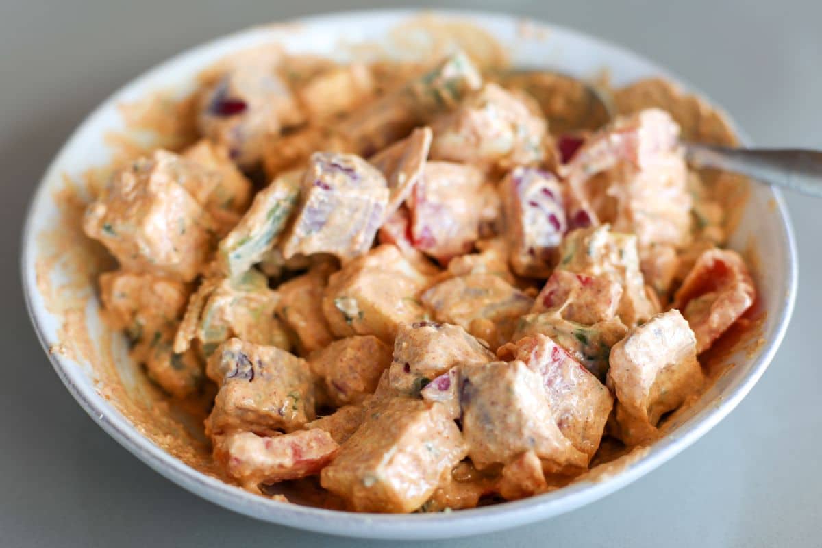 A bowl of paneer, red onions, and bell peppers coated with paneer tikka marinade.