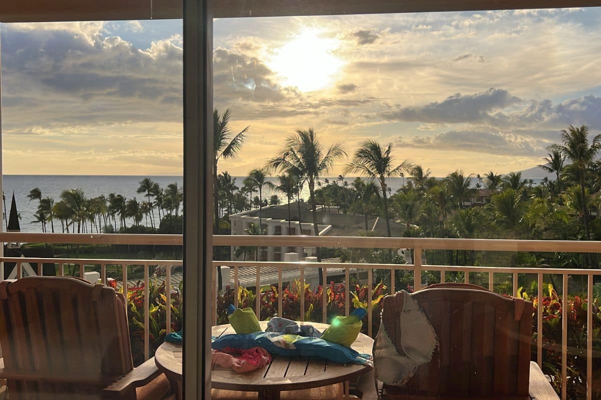 Oceanview room at the Grand Wailea Maui with a view of the ocean, sun, and palm trees.