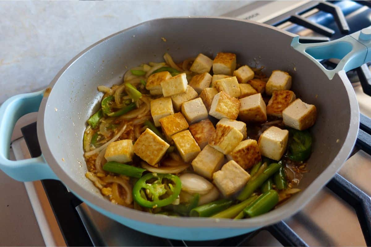 Add cubed tofu to sauteed veggies and Asian sauce.
