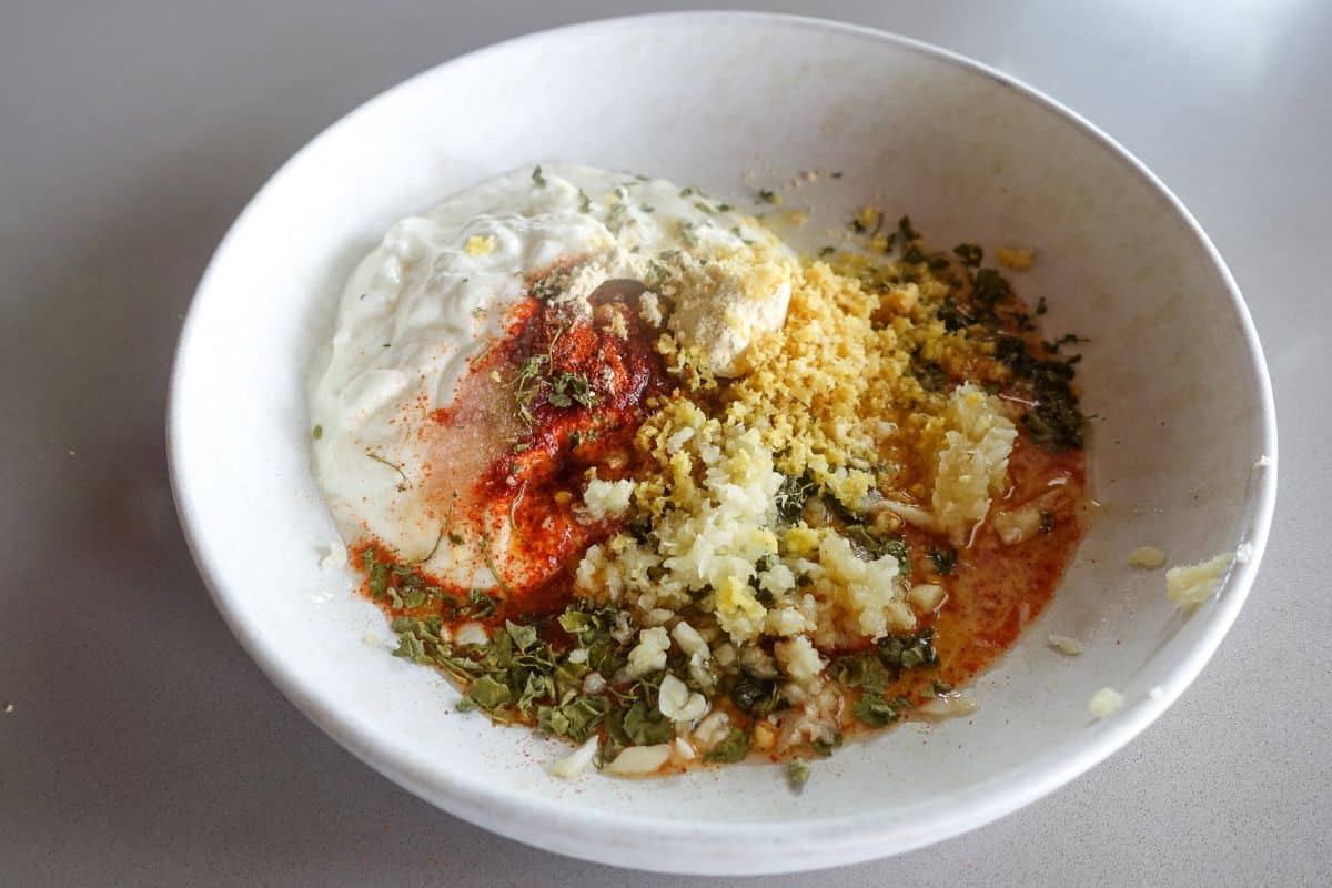 Add yogurt and spices in a bowl to prepare the tandoori marinade.