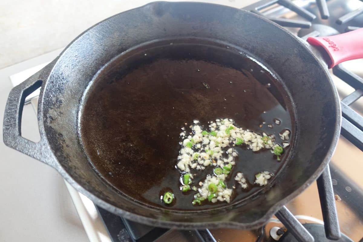 Saute garlic and green chilies in oil on a castirion skillet.