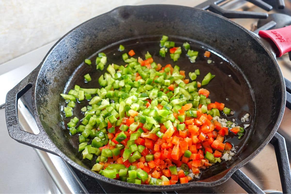 Add bell peppers and onions on a castirion skillet.
