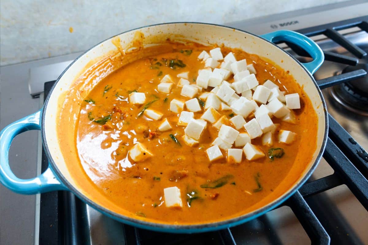 Add small cubes of paneer to a coconut milk sauce in an enameled braiser to make marry me paneer.