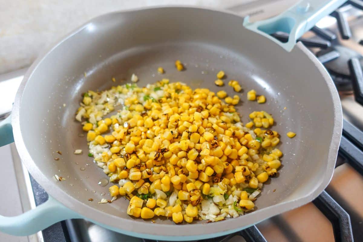 Corn added to nonstick pan.
