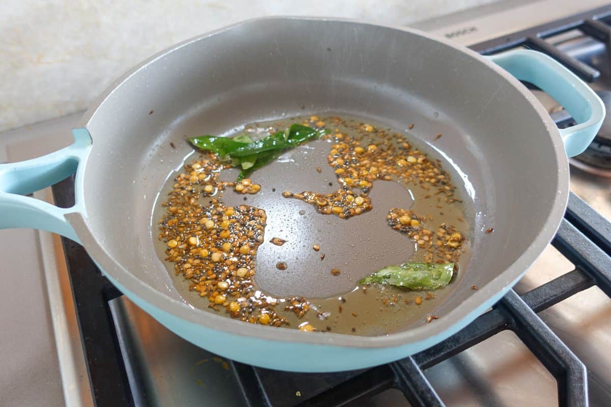 In a pan there is oil, sauteed whole spices and curry leaves.