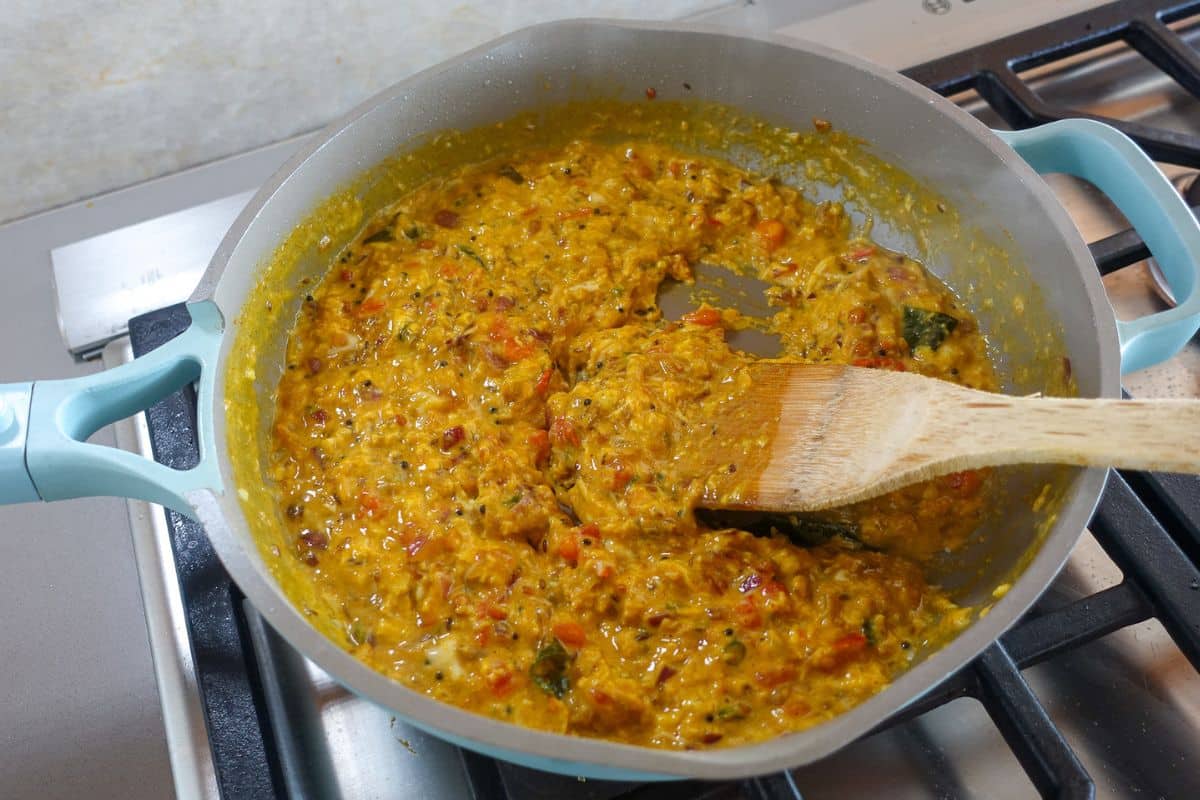 Scramble egg bhurji with a wooden spoon inside a pan.