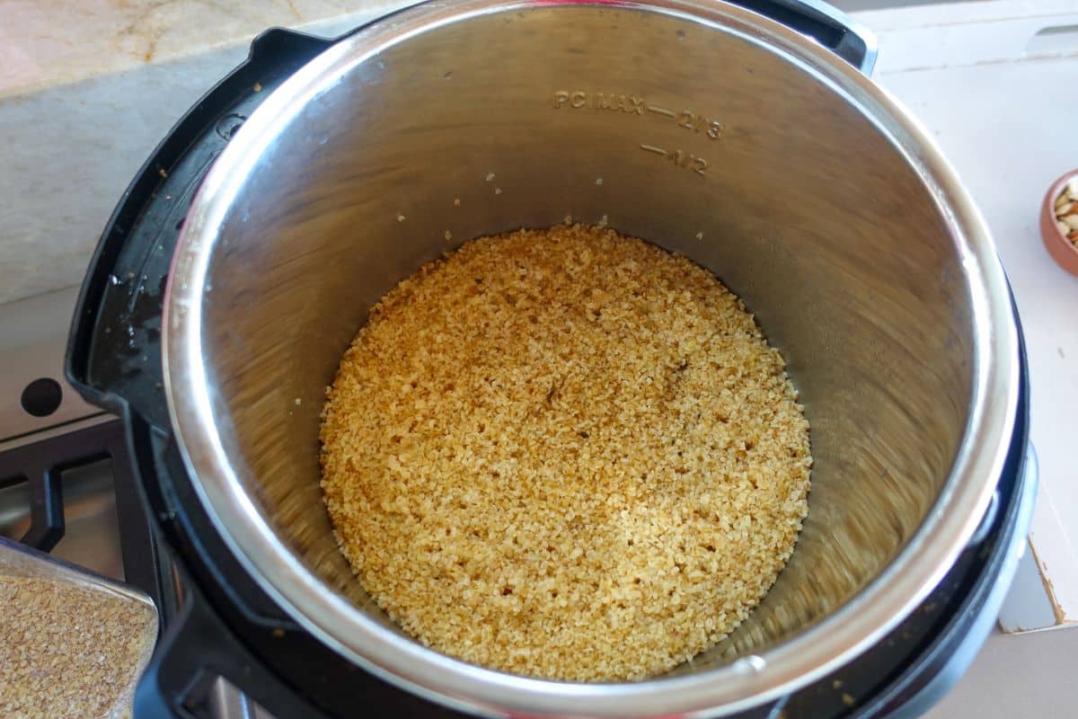 Cooked daliya in the Instant Pot on a kitchen counter.
